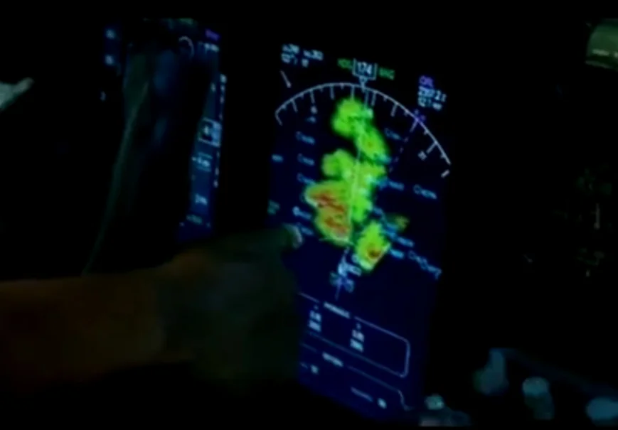 Tela de radar (filme "O voo") - regiões vermelha possuem chuva forte e turbulência severa e regiões verdes, chuva moderada (O avião passa entre as duas regiões vermelhas)
