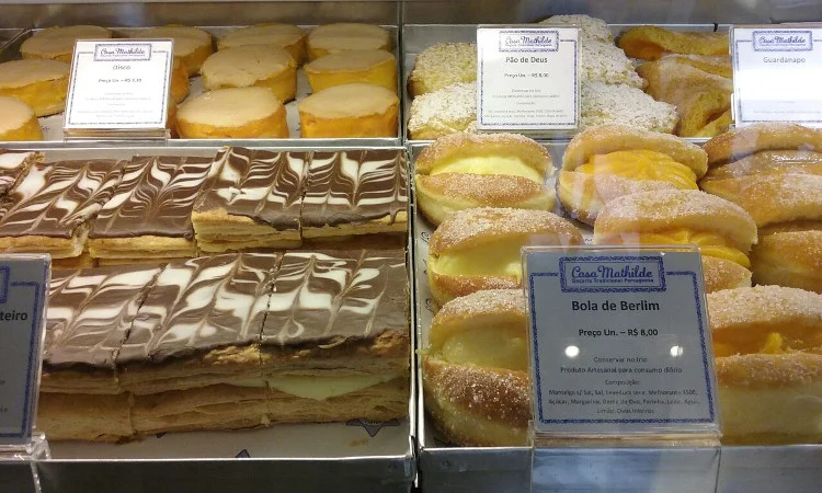 Disco, pão de Deus, guardanapo, bola de Berlim (creme, creme de ovos ou doce de leite) e folhado com cobertura de chocolate (no sentido horário). Foto: ViniRoger