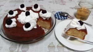 Babá ao rum da receita decorada com chantilly e cerejas e pote com calda extra. Foto: ViniRoger