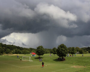 Tempestade com raios se aproximando de campo de futebol. Créditos: woodleywonderworks