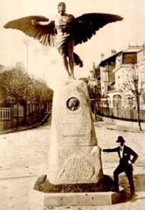 Santos Dumont posando na estátua em sua homenagem em 1913. Fonte: Wikipedia
