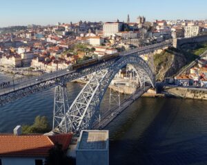 Ponte de D. Luís vista a partir de miradouro da Serra do Pilar, em Gaia; ao centro, observa-se a Torre dos Clérigos e a Sé do Porto. Foto: ViniRoger