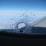 Orifício de equalização de pressão em uma janela de avião, com cristais de gelo formados devido à sublimação do vapor d'água interno da cabine. Fonte: Chris Waits