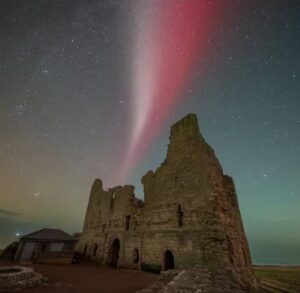O fenômeno Steve visto no céu sobre o Castelo de Dunstanburgh, no norte da Inglaterra, em 07/10/2024. Foto: Ian Sproat/@mje_photography_ne via g1