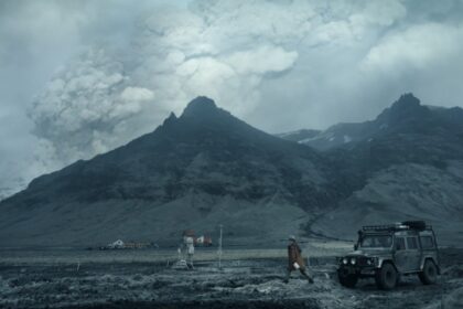 Início do primeiro episódio da série Katla: vulcão ao fundo em erupção, com estação meteorológica em primeiro plano