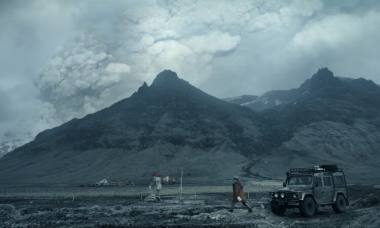 Início do primeiro episódio da série Katla: vulcão ao fundo em erupção, com estação meteorológica em primeiro plano