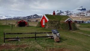 Lindarbakki em Bakkagerði (casa com telhado de turfa e montanhas com neve ao fundo). Foto: ViniRoger